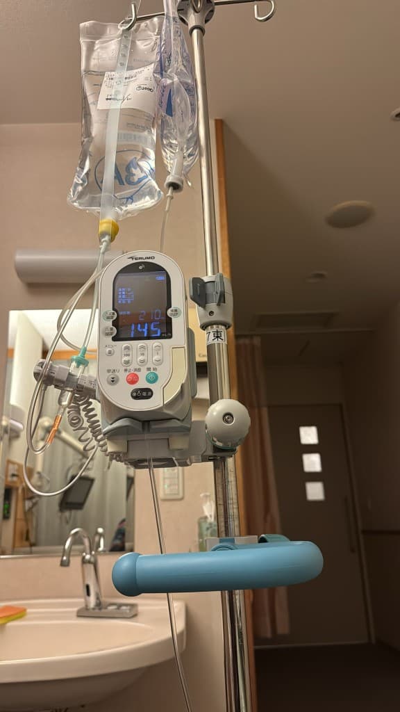 IV pole with saline bags and infusion pump in hospital ward
